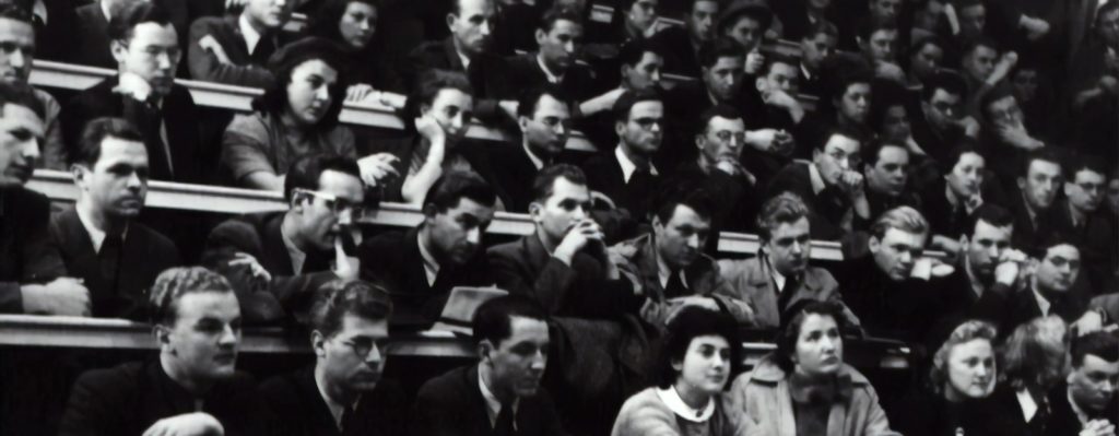 grayscale photography of people sitting on crowd chair